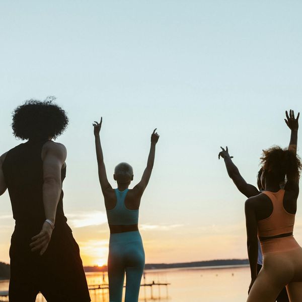 Group of diverse people practicing yoga together outdoors.